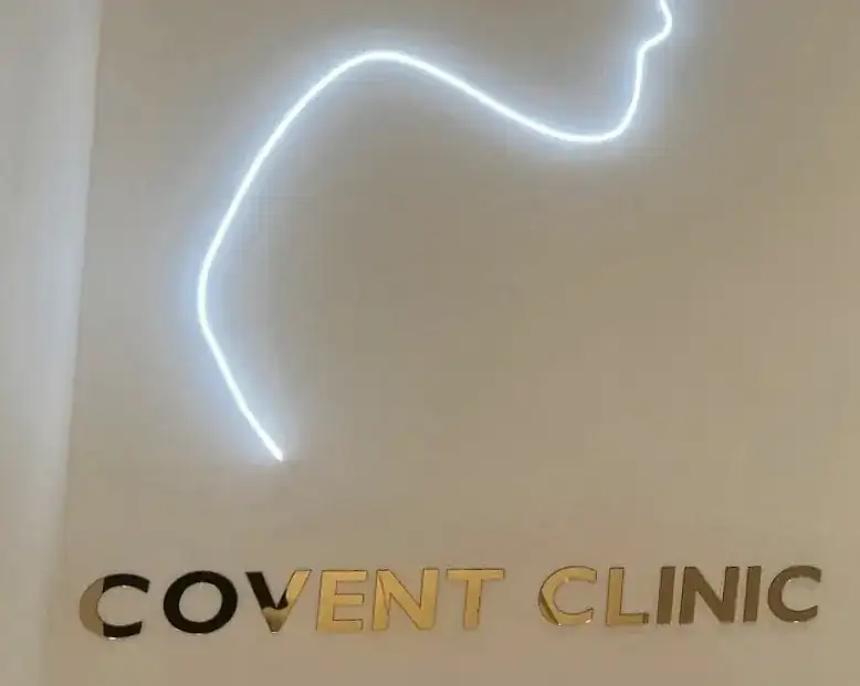 Gold COVENT CLINIC letters under a white neon face-profile line, made by AdsyUp in Dublin