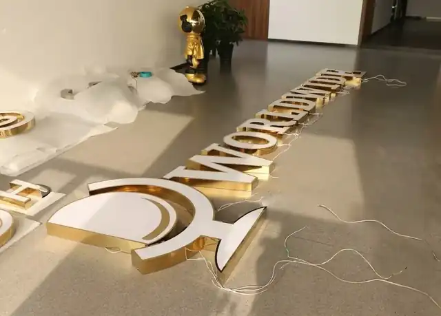 WORLDWIDE gold mirror letters and logo laid out in production