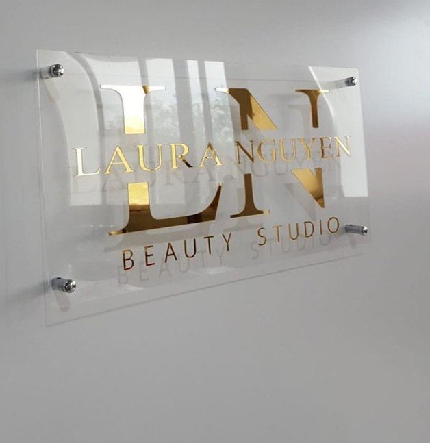 Clear acrylic reception wall sign with gold mirror monogram and name letters on steel standoffs