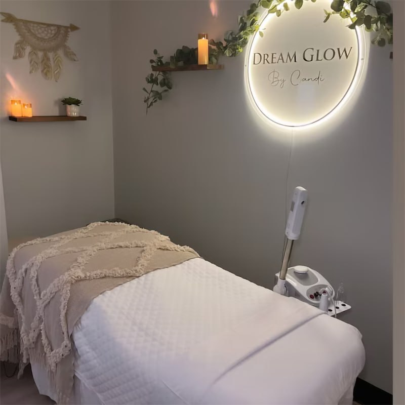 Backlit round logo sign glowing on the wall of a beauty treatment room