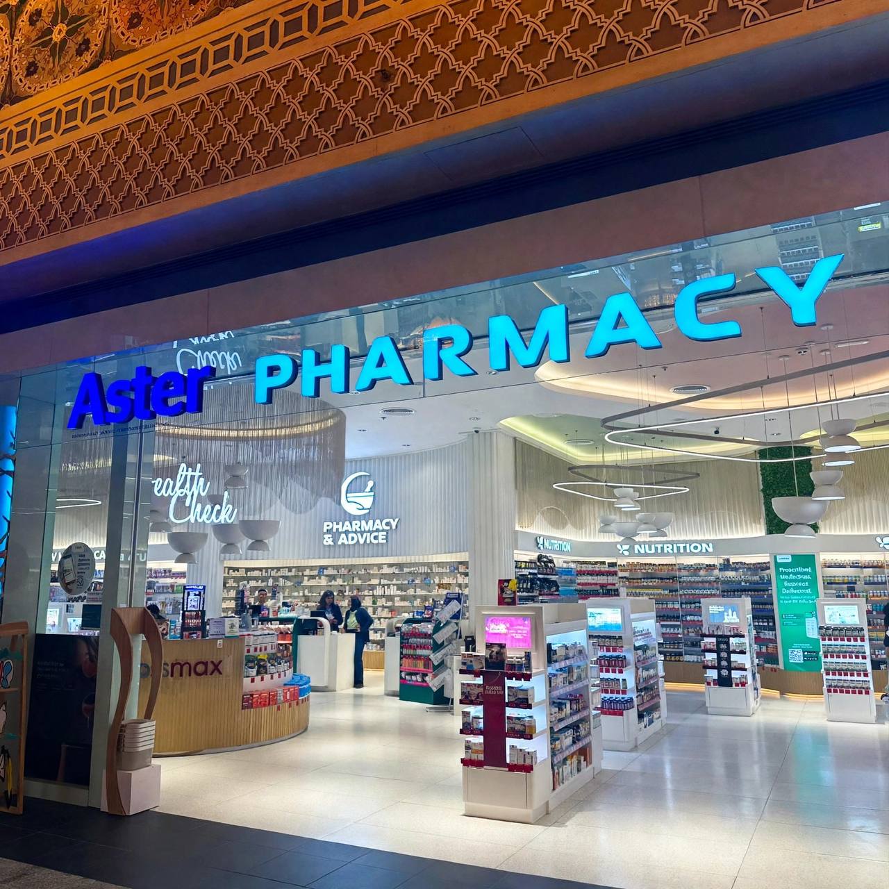 Close view of the illuminated 3D letters Aster PHARMACY above the entrance