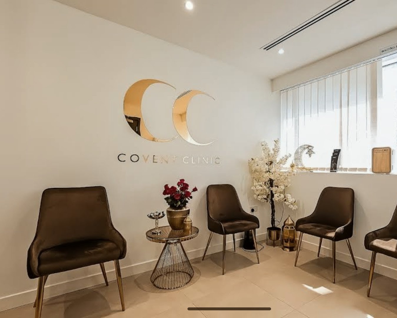 Covent Clinic waiting room with the mirror gold CC logo and COVENT CLINIC lettering on the wall