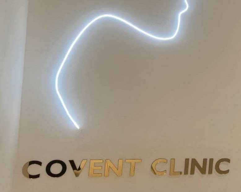 Gold mirror COVENT CLINIC letters under a white neon line drawing