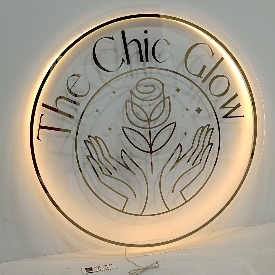 Round backlit clear acrylic sign with gold mirror line-art logo and lettering