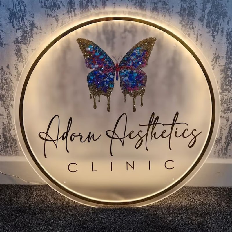 Backlit round frosted acrylic clinic sign with gold mirror ring and printed butterfly logo