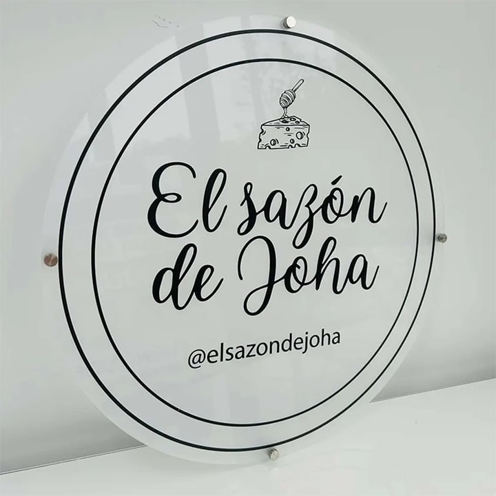 Round white acrylic wall sign with black printed logo, mounted on steel standoffs